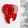 Red tooth wall clock hanging in a dental operatory room for precise timekeeping